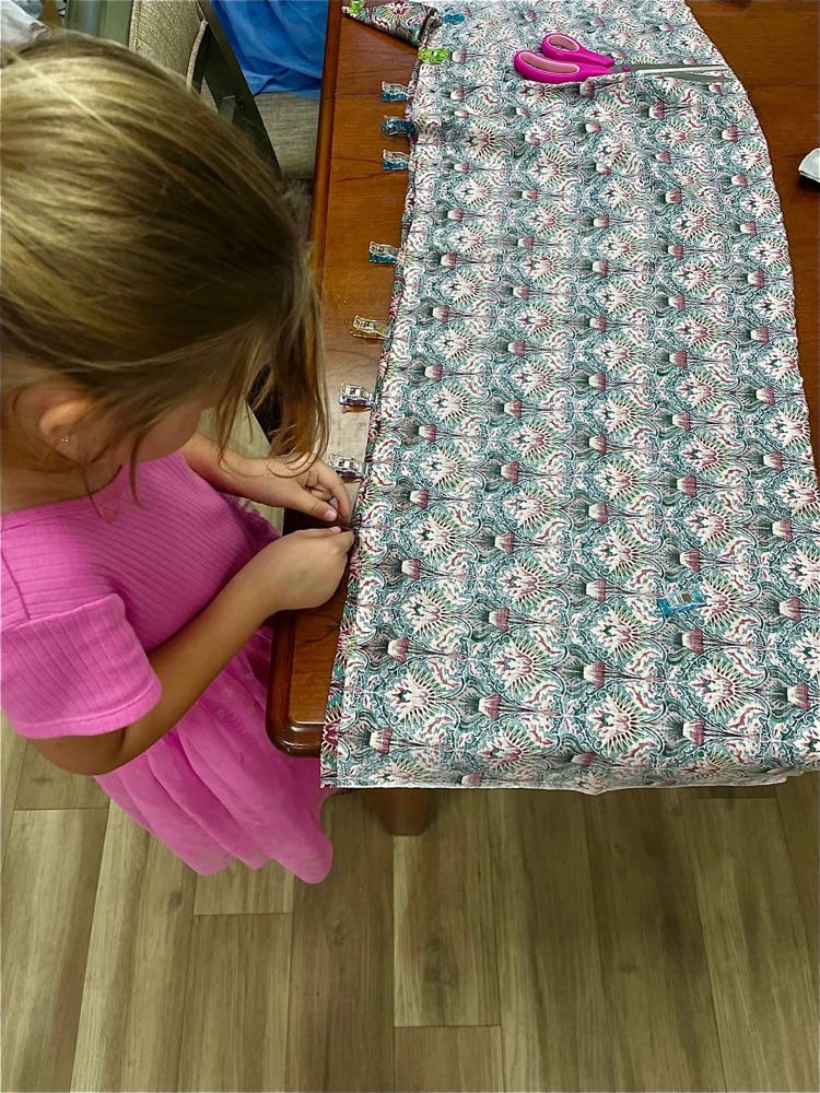 Young student pinning fabric at the worktable